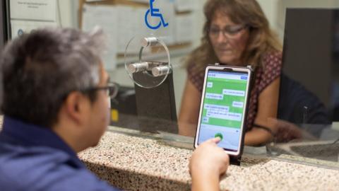 Customer using translation assistance device at Chandler Municipal Court